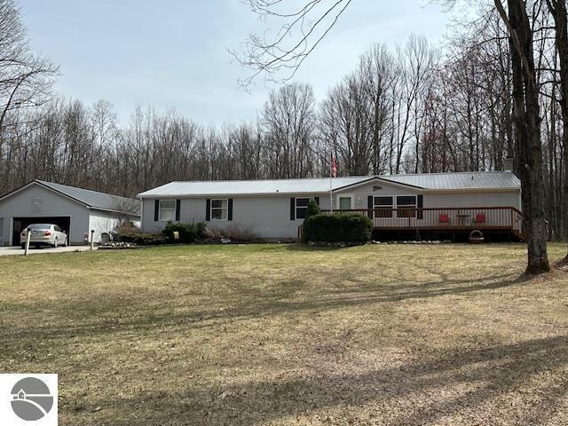 4607 Del Mason Rd, Bellaire, MI 49615 - view of front of home with a deck, a garage, a front lawn, and an outbuilding