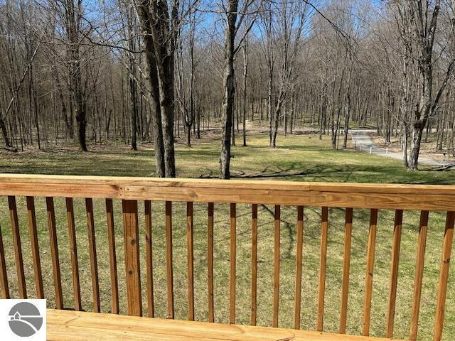 4607 Del Mason Rd, Bellaire, MI 49615 - wooden deck featuring a lawn