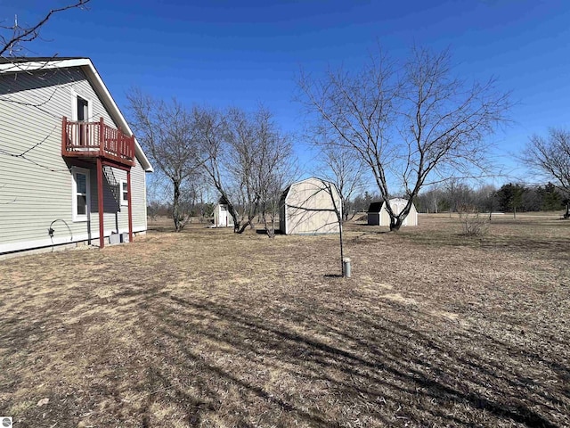 5071 Corey Rd, Mancelona, MI 49659 - view of yard with an outdoor structure, a shed, and a balcony