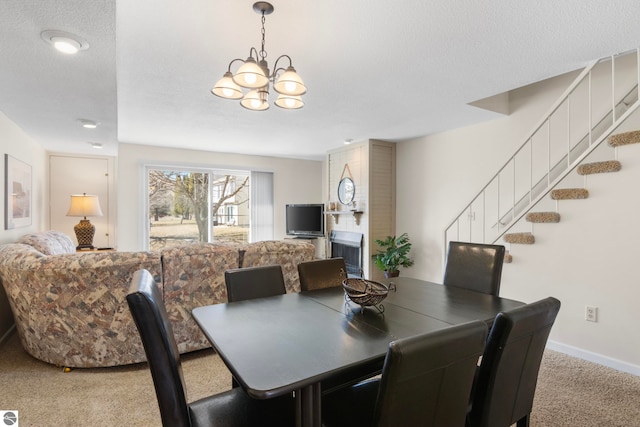 5000 Townhouse Dr, Cedar, MI 49621 - dining space featuring baseboards, a chandelier, a textured ceiling, carpet floors, and stairs