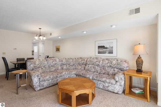 5000 Townhouse Dr, Cedar, MI 49621 - carpeted living area with visible vents, baseboards, and a notable chandelier