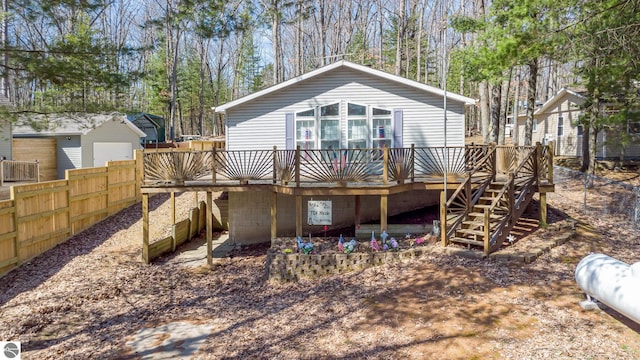 rear view of property with stairway, a wooden deck, and fence