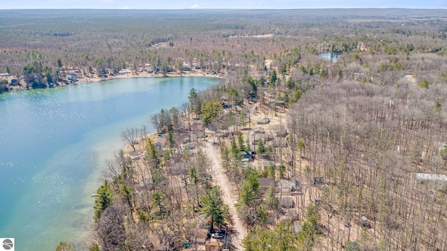 birds eye view of property featuring a forest view and a water view
