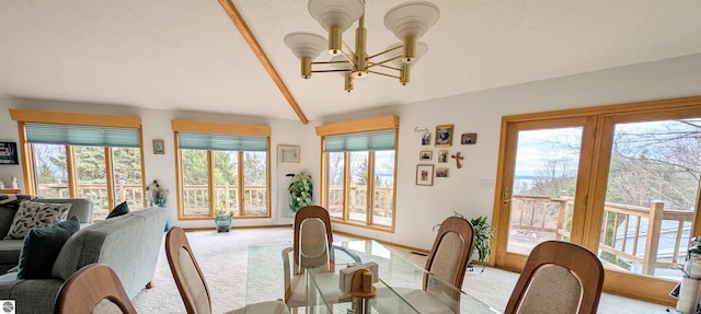 carpeted dining space with a notable chandelier, baseboards, and vaulted ceiling with beams
