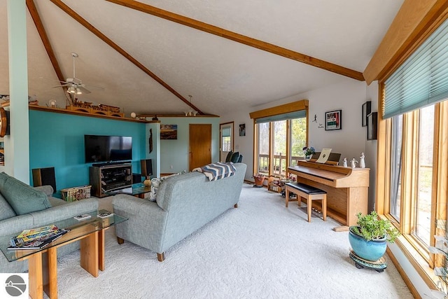 living area with vaulted ceiling with beams, carpet flooring, and a ceiling fan