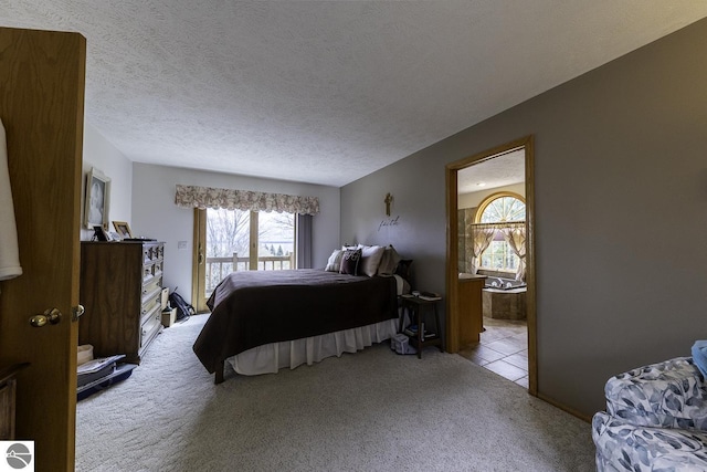 bedroom with carpet, ensuite bath, multiple windows, and a textured ceiling