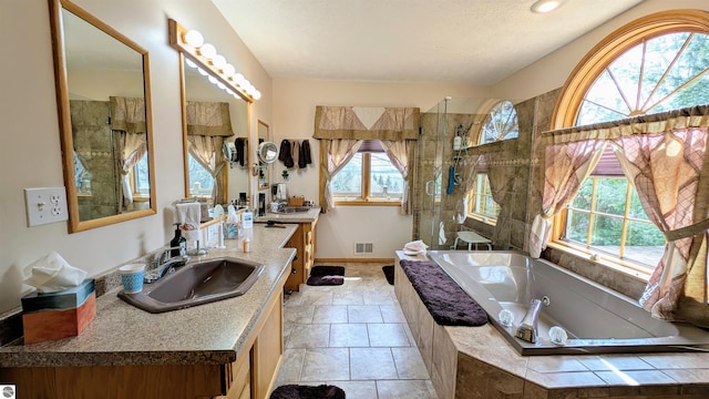 bathroom featuring visible vents, baseboards, a tub with jets, a shower stall, and vanity