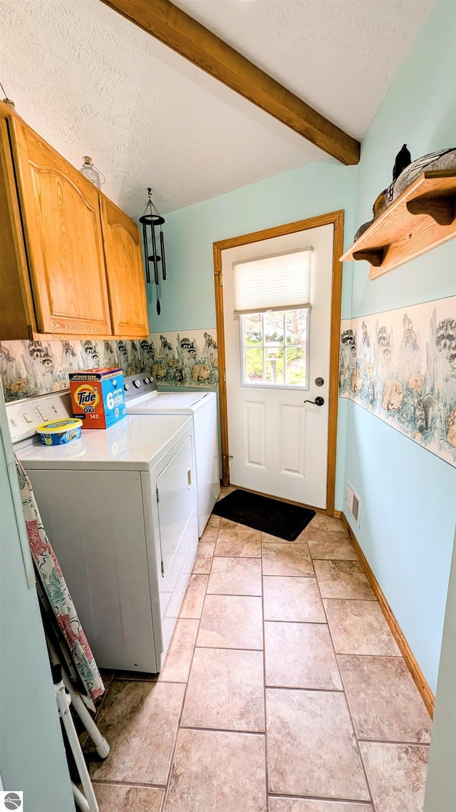 laundry room featuring baseboards, a textured ceiling, visible vents, cabinet space, and washer and dryer