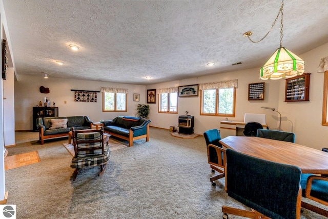 carpeted living room with recessed lighting, a wood stove, and a textured ceiling