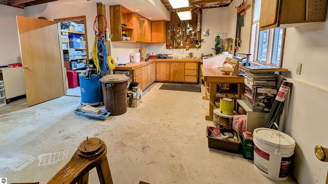 kitchen featuring brown cabinets, concrete flooring, and open shelves