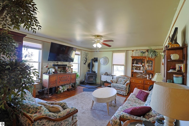 2587 S Coldwater Rd, Mount Pleasant, MI 48858 - living room featuring a wood stove, ceiling fan, and wood finished floors