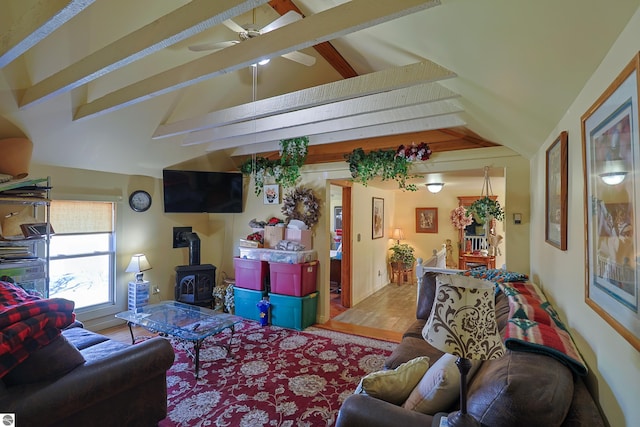 2587 S Coldwater Rd, Mount Pleasant, MI 48858 - living room featuring wood finished floors, a wood stove, lofted ceiling with beams, and a ceiling fan
