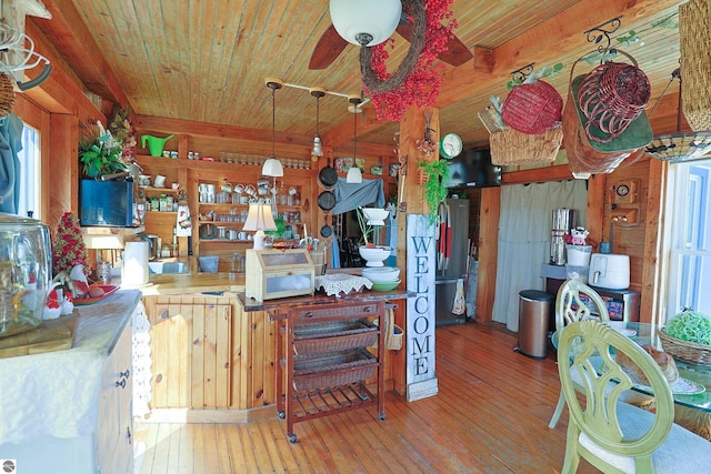 2587 S Coldwater Rd, Mount Pleasant, MI 48858 - kitchen with wooden ceiling, wooden walls, wood-type flooring, and freestanding refrigerator