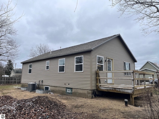 back of property with roof with shingles, fence, a deck, and cooling unit