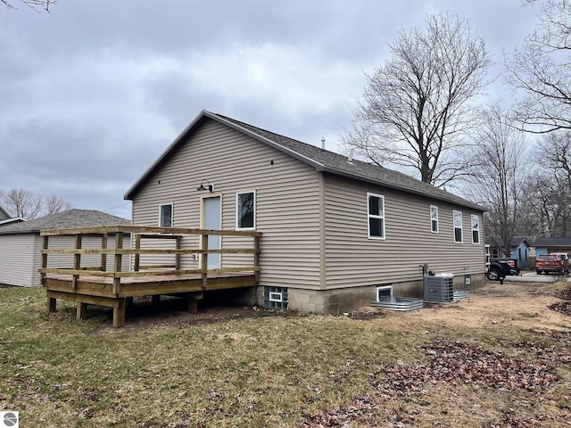 rear view of house featuring a shingled roof, central air condition unit, and a deck