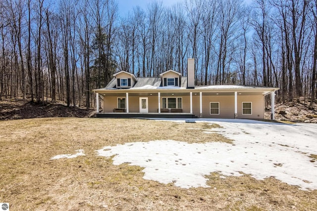 view of front of property featuring a chimney and covered porch