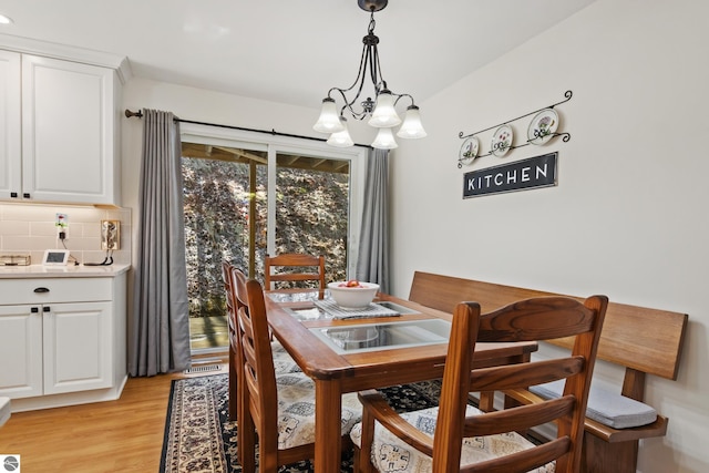 dining room featuring light wood-style flooring and a notable chandelier