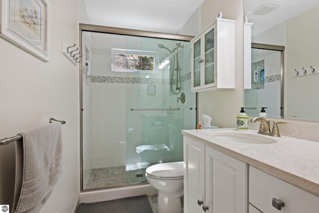 bathroom featuring vanity, visible vents, a stall shower, and toilet