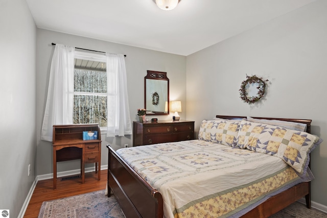bedroom with wood finished floors and baseboards