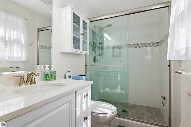 bathroom featuring a shower stall, vanity, and toilet