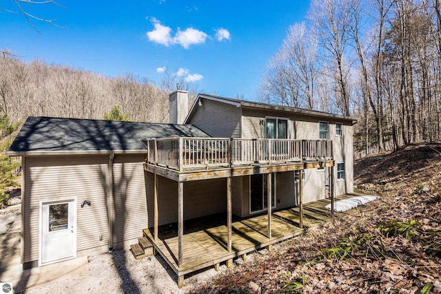 rear view of house with a deck and a chimney