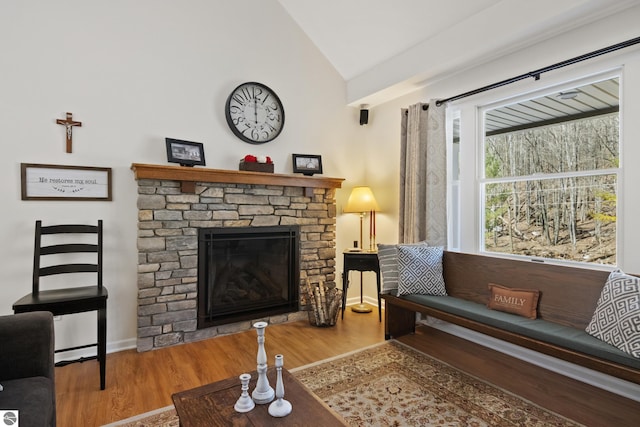living room with baseboards, wood finished floors, a fireplace, and vaulted ceiling