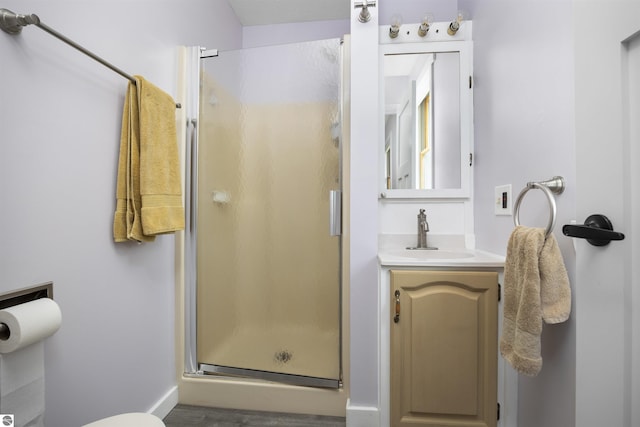 full bathroom with toilet, a stall shower, wood finished floors, and vanity