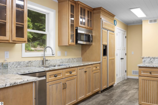 kitchen featuring visible vents, a sink, light stone counters, and appliances with stainless steel finishes