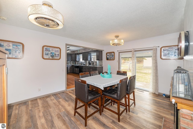 4631 Cardinal Dr, Mount Pleasant, MI 48858 - dining area with visible vents, baseboards, wood finished floors, and a textured ceiling