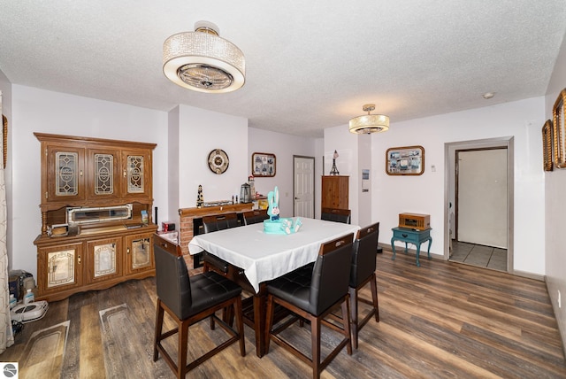 4631 Cardinal Dr, Mount Pleasant, MI 48858 - dining space featuring a textured ceiling, dark wood-style flooring, and baseboards