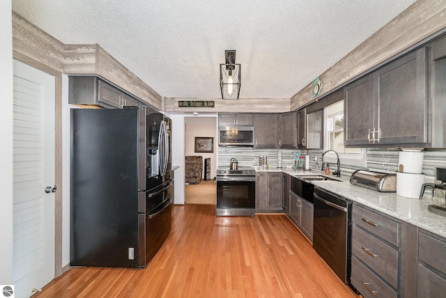 4631 Cardinal Dr, Mount Pleasant, MI 48858 - kitchen with backsplash, dark brown cabinets, light wood-style floors, appliances with stainless steel finishes, and a sink