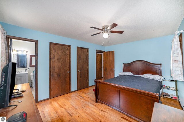 4631 Cardinal Dr, Mount Pleasant, MI 48858 - bedroom with ensuite bathroom, a sink, a ceiling fan, multiple closets, and light wood-style flooring