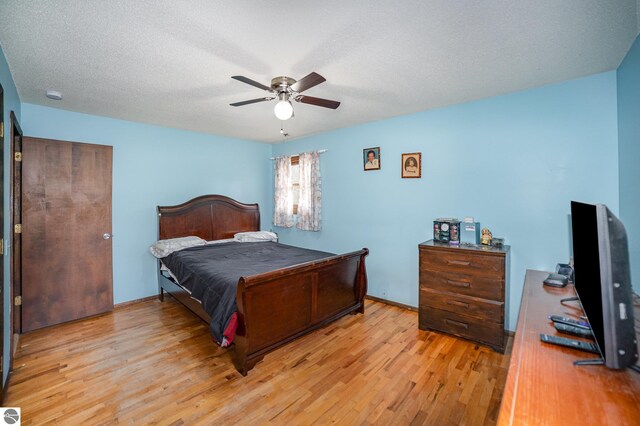 4631 Cardinal Dr, Mount Pleasant, MI 48858 - bedroom with light wood-style flooring, a ceiling fan, and a textured ceiling