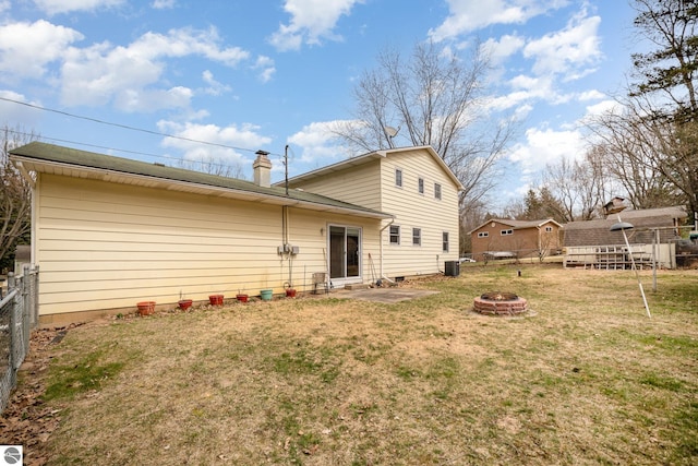 4631 Cardinal Dr, Mount Pleasant, MI 48858 - back of property featuring cooling unit, a yard, fence, a fire pit, and a chimney