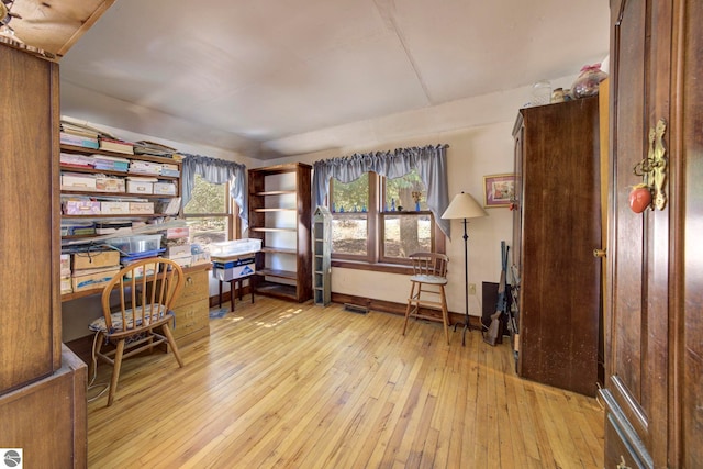 office space with baseboards and light wood-type flooring