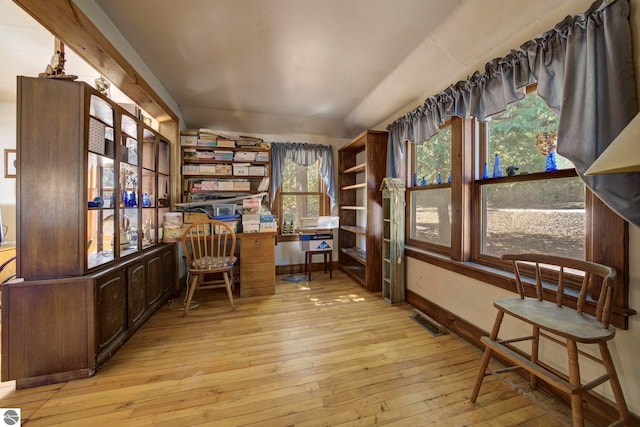 sitting room featuring light wood finished floors, vaulted ceiling, and visible vents