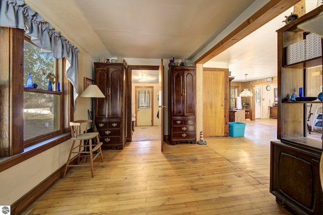 hallway featuring light wood-style flooring and baseboards