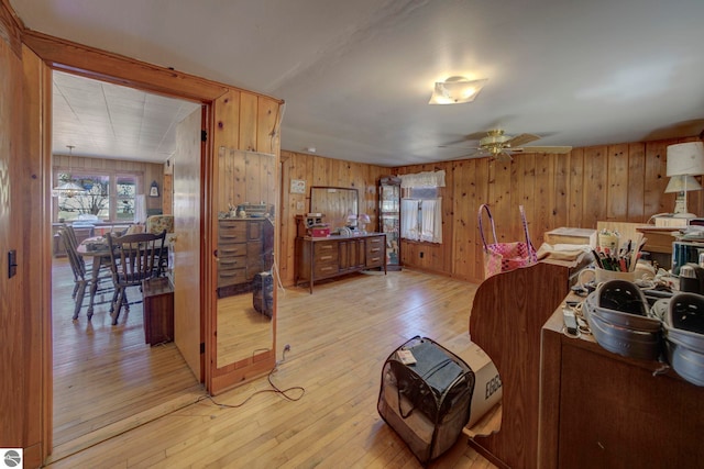 bedroom featuring wooden walls, multiple windows, and light wood finished floors