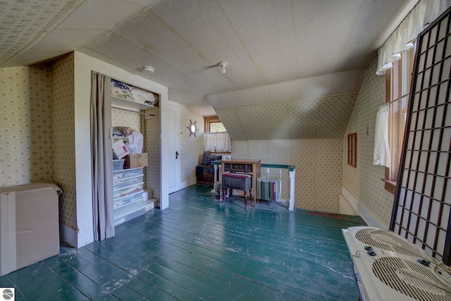 bonus room featuring hardwood / wood-style floors, wallpapered walls, and lofted ceiling