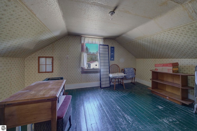 bedroom featuring wood-type flooring, baseboards, wallpapered walls, and lofted ceiling