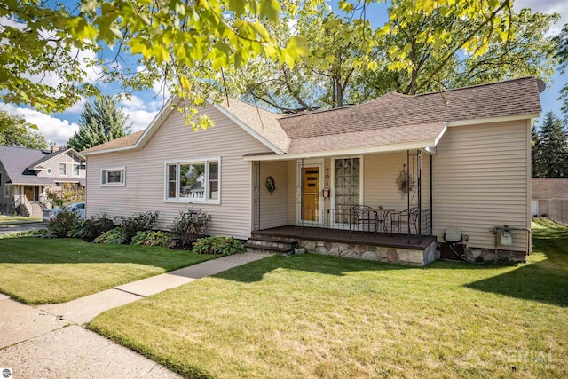 single story home featuring a porch, a front yard, and roof with shingles