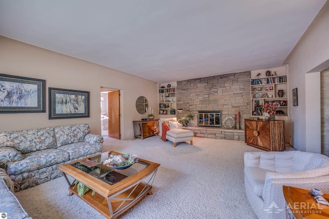 carpeted living area featuring built in shelves and a stone fireplace