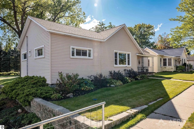 single story home with a shingled roof and a front lawn