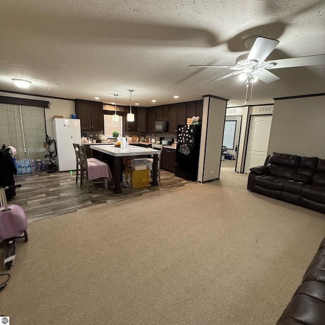 1279 Beacon Hill Ct, Mount Pleasant, MI 48858 - living area with dark carpet, a textured ceiling, and a ceiling fan