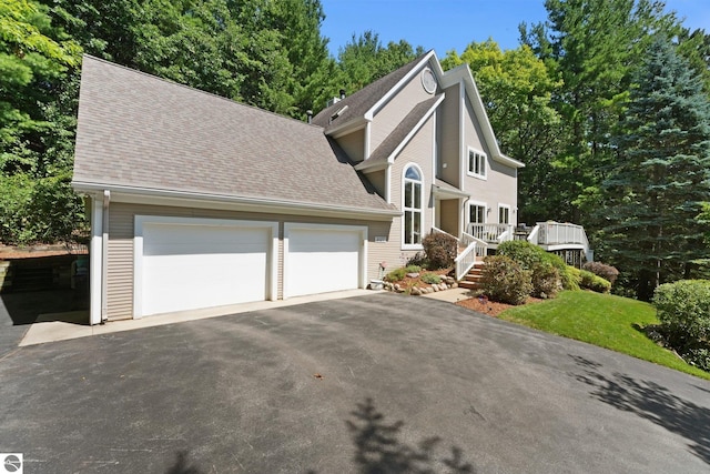 2127 E Timberlane Dr, Traverse City, MI 49686 - view of front of house featuring an attached garage, a shingled roof, and aphalt driveway