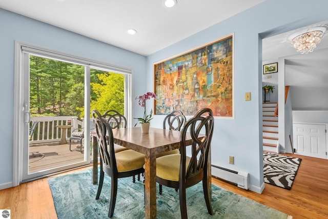 2127 E Timberlane Dr, Traverse City, MI 49686 - dining space featuring wood finished floors, a baseboard heating unit, baseboards, and stairs
