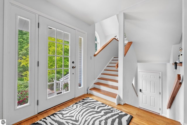 2127 E Timberlane Dr, Traverse City, MI 49686 - entrance foyer with a wealth of natural light, stairway, vaulted ceiling, and wood finished floors