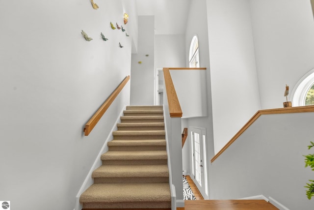 2127 E Timberlane Dr, Traverse City, MI 49686 - stairway featuring baseboards, wood finished floors, and a towering ceiling