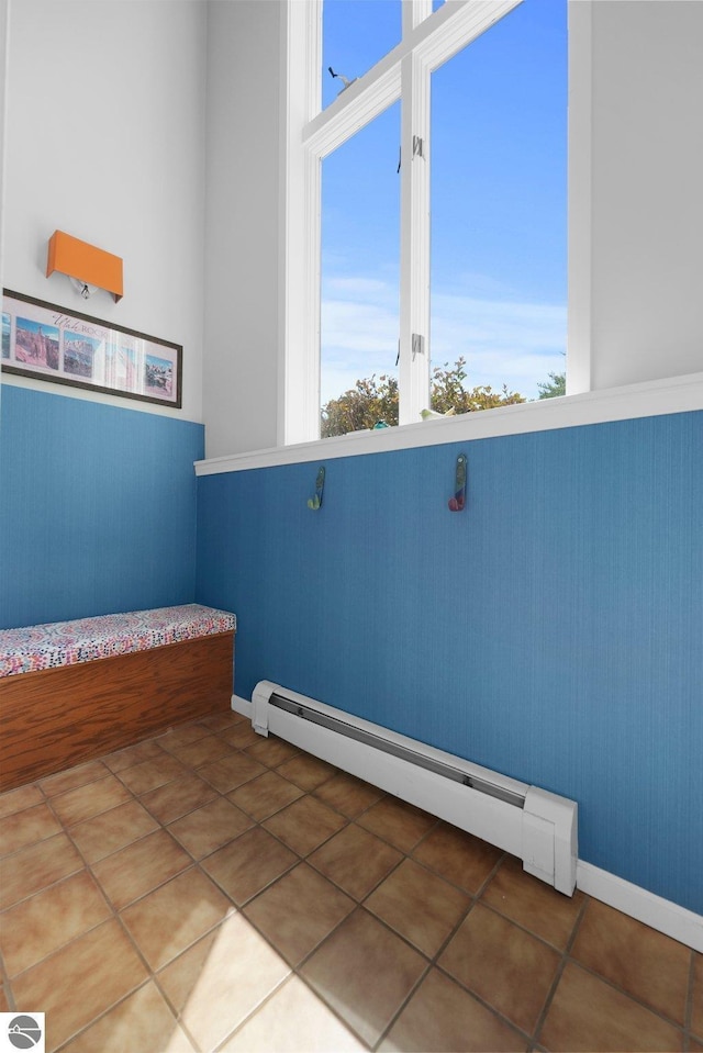 2127 E Timberlane Dr, Traverse City, MI 49686 - empty room featuring a wainscoted wall, a baseboard radiator, tile patterned flooring, and baseboards