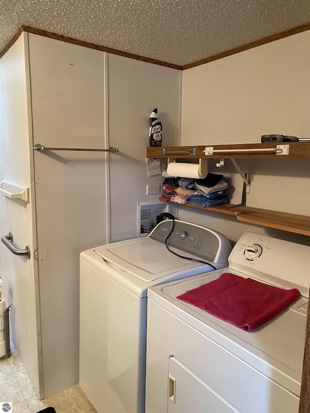 washroom with washer and dryer, crown molding, and light tile patterned floors